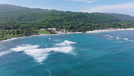 Olas-Rompiendo-En-Un-Resort-De-Playa-De-Arena-Tropical-En-El-Quemaito,-Drone-Adelante