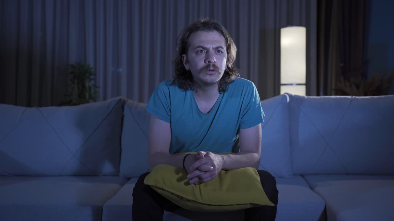 Man watching tv at night at home.