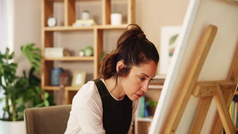 woman painting a canvas in a home studio