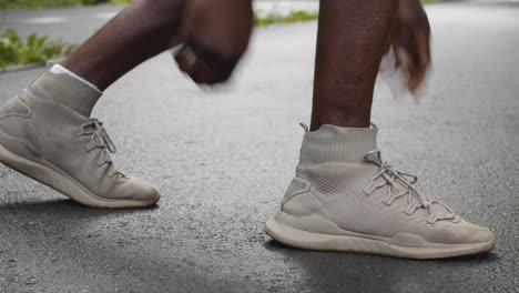 man tying his running shoes on the road