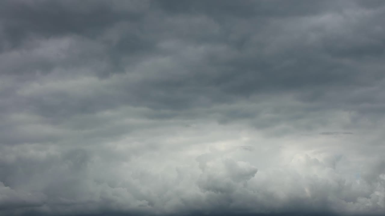 Slow dramatic painterly layers of cumulus cloud formations coming up and being obscured by blanket against a blue sky