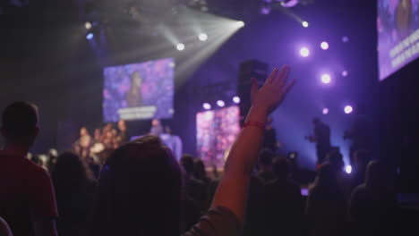people raising their hands at a concert