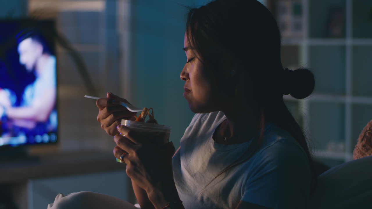 Woman Eating Dinner While Watching TV in Bed