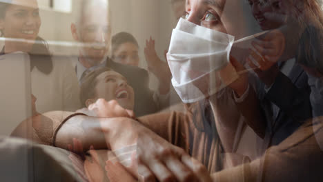 woman in face mask against office colleagues celebrating together