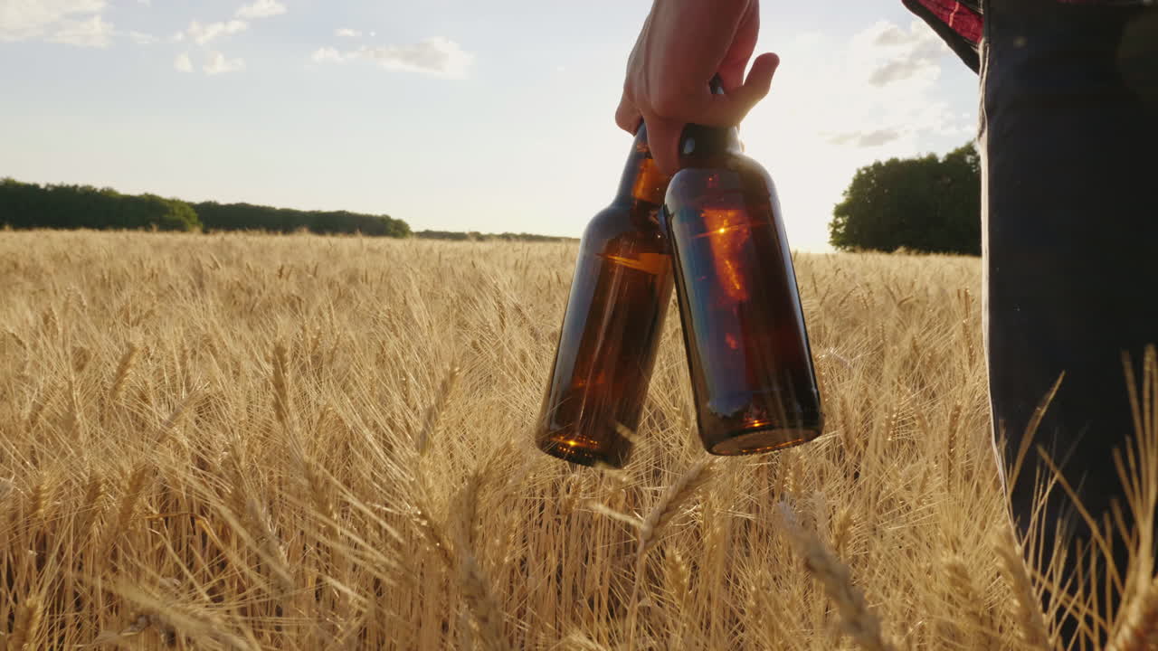 맥주 두 병을 들고 밀밭을 걷는 남자