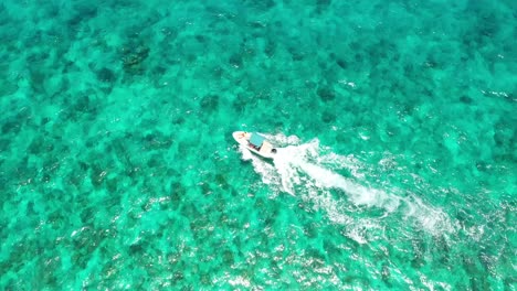 White-speed-boat-with-tourists-sailing-on-clear-turquoise-sea-surface