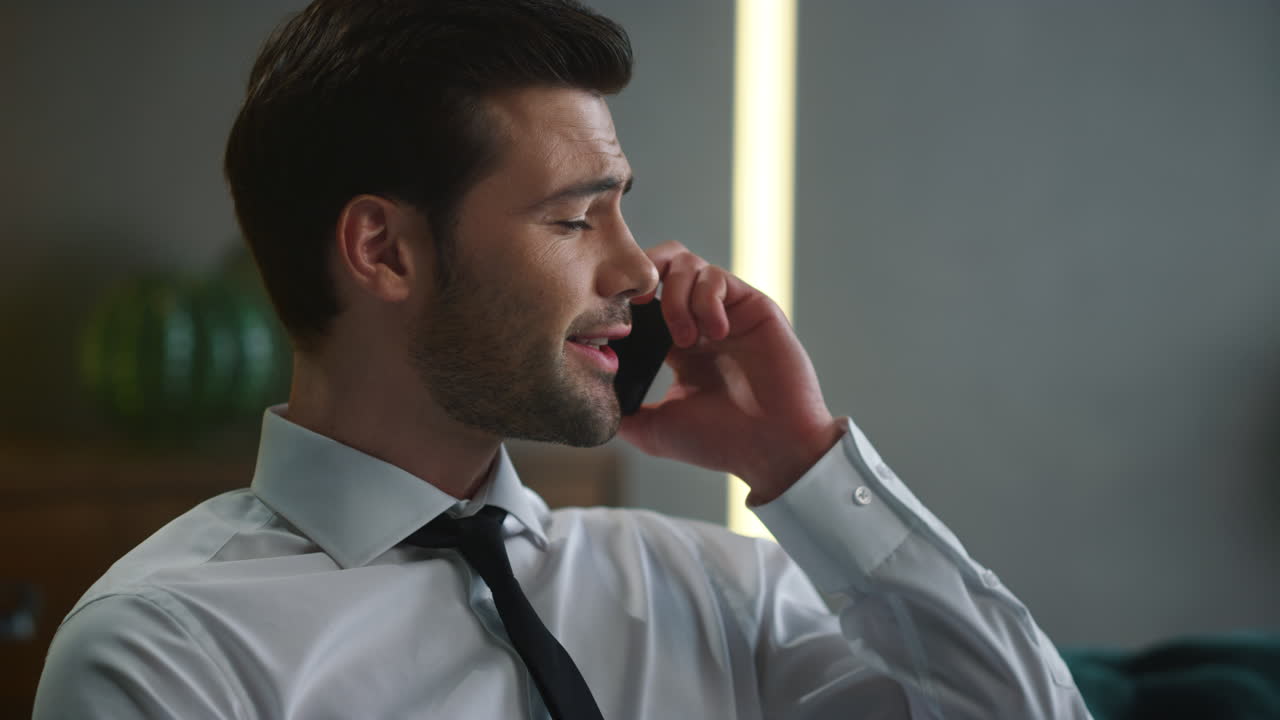 Businessman talking on smartphone in office. Employee calling on cellphone