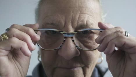 close up elder senior woman portrait wearing glasses in slow motion