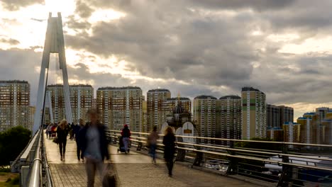 mucha gente caminando por el puente peatonal a la nueva zona residencial, el lapso de tiempo