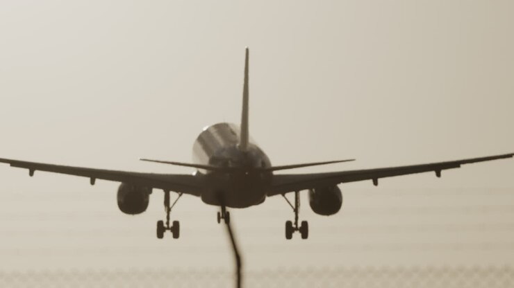 aereo in volo sopra la testa per atterrare in aeroporto al rallentatore al tramonto