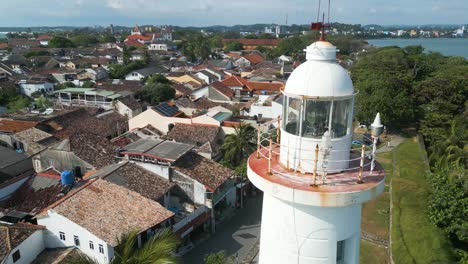 aerial shot over the top of the white lighthouse of galle dutch fort in sri lanka