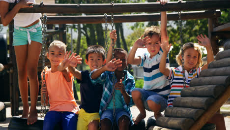 Porträt-Glücklicher-Schulkinder,-Die-Auf-Dem-Spielplatz-Mit-Den-Händen-Winken