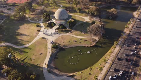 Aerial-flyover-Planetarium-with-tourist-beside-lake-and-traffic-on-highway-road-in-Buenos-Aires