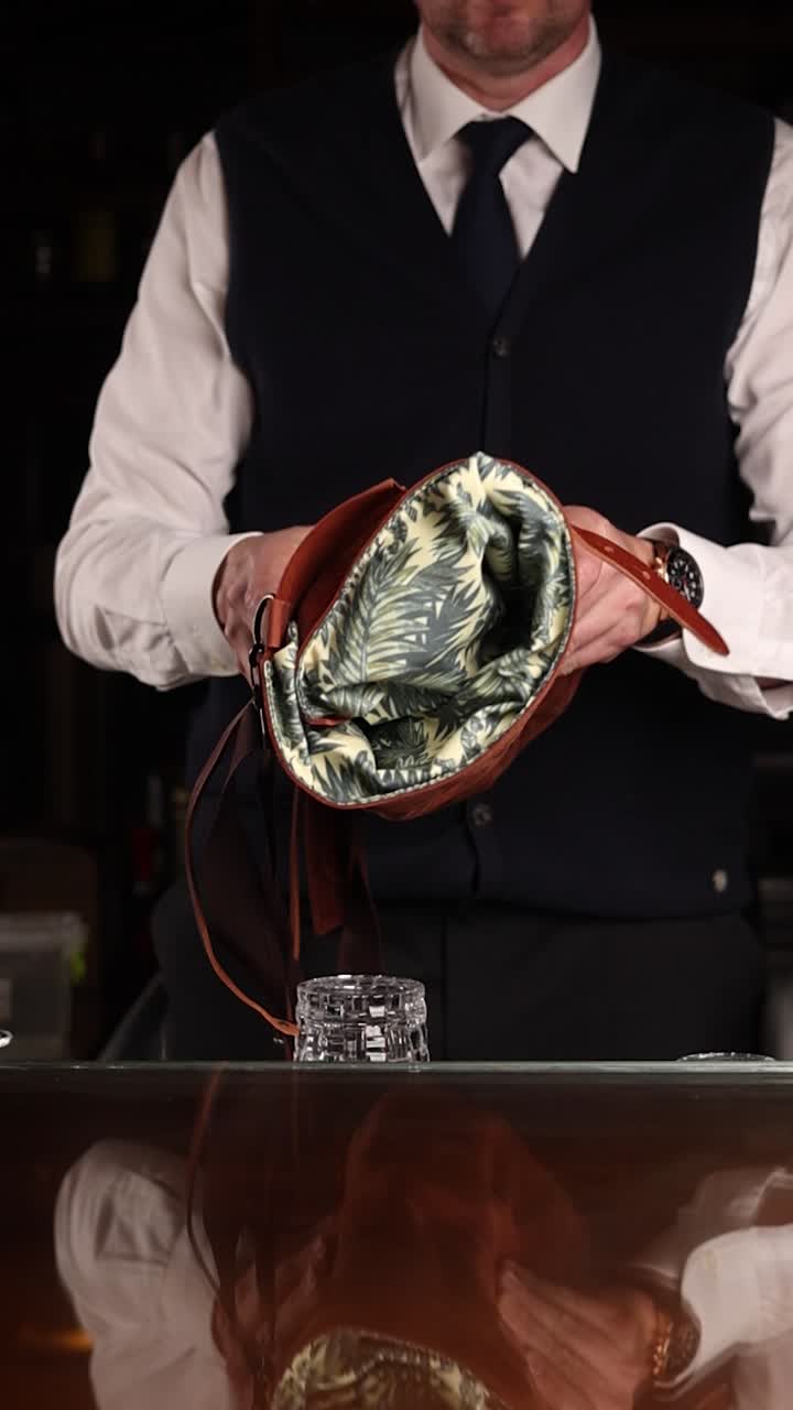 Man opening a brown leather backpack