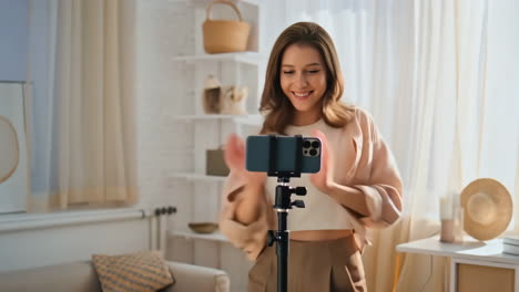 a young woman recording a video blog at home with her smartphone
