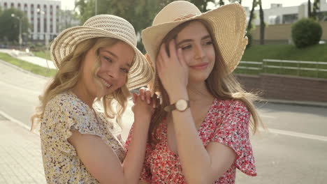 two happy women wearing straw hats and floral dresses