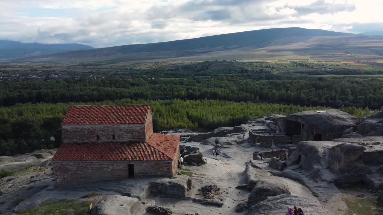 Wide drone of Uplistsikhe cave city with surrounding plains and ancient stone structures