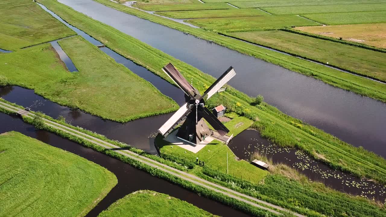 밀을 향해 날아가는 네덜란드 풍경의 전통적인 풍차