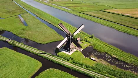 traditional windmill in dutch landscape aerial shot flying towards the mill