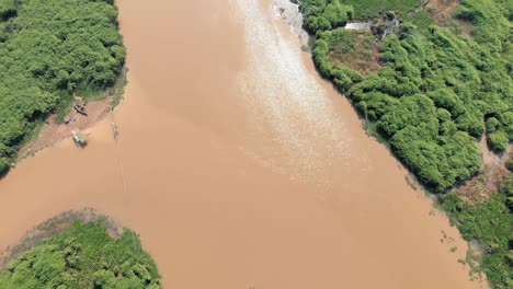 Blick-Von-Oben-Nach-Unten-Auf-Den-See-Von-Zwei-Schwimmenden-Gebäuden-Bis-Dahinter-Mit-Seiner-Grünen-Dschungelküste