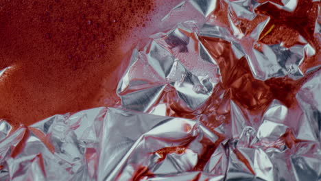 crumpled aluminum foil with red liquid