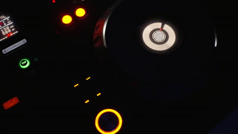 close-up of a dj mixer with glowing buttons and knobs