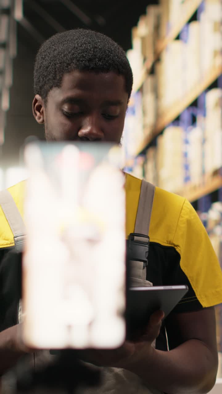 Vertical Video Black e-commerce worker filming a promotional video inside a fulfillment center