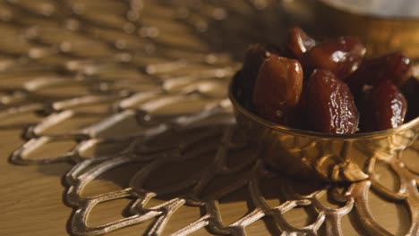 close up of bowl of dates on table in muslim home celebrating eid