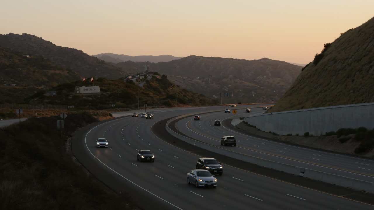 Motorvejs-solnedgang time-lapse i Simi Valley, Californien, USA, med 'Velkommen til Simi Valley'-skilt, optaget i 4K høj opløsning.