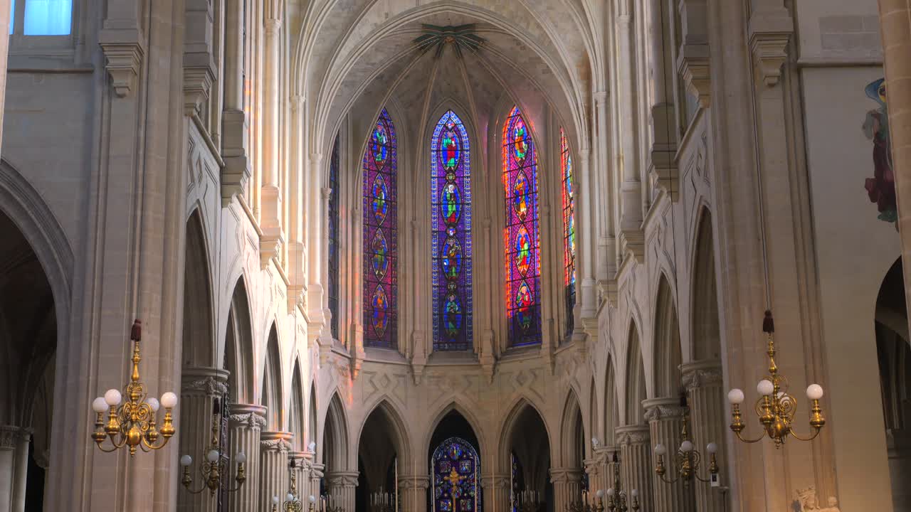 Tilt up shot of dimly lit alter in the interior of a roman catholic church of Saint-Germain-l'Auxerrois in Paris, France