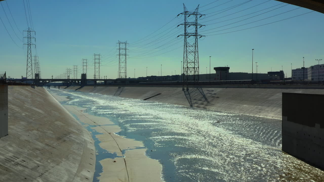 volando bajo a la derecha de las vías del tren junto al río la con un espectacular dtla al fondo, ee.uu. california