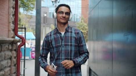 young man walking in the city with headphones