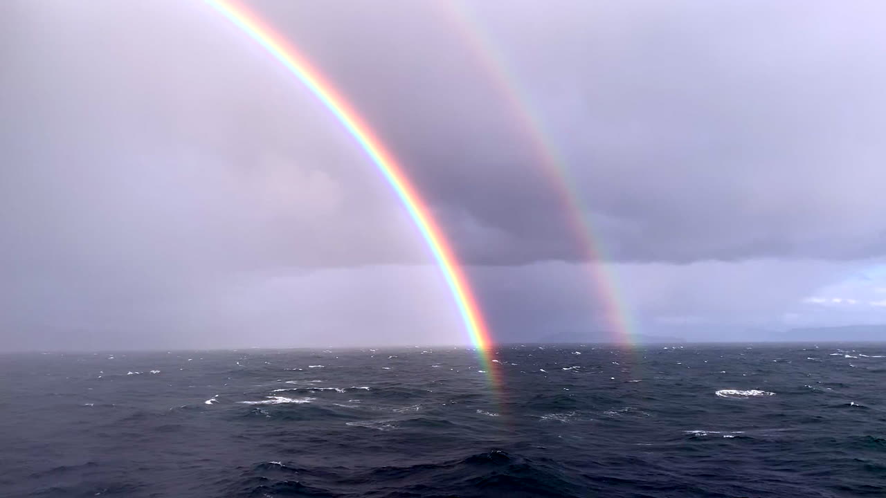 hermoso - arco iris doble raro sobre el océano desde un crucero en el mar del norte frente a la costa de noruega en el círculo polar ártico tiro más largo 1080p