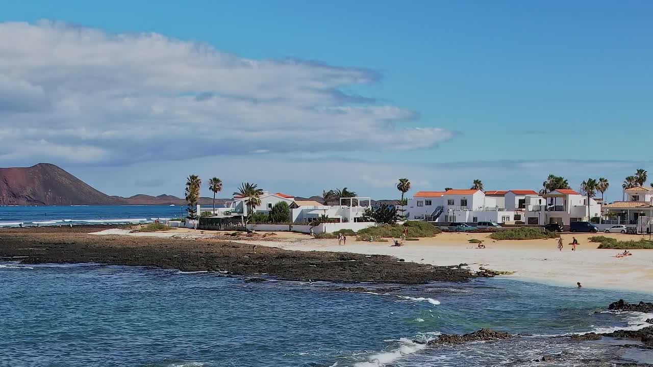 Scena da spiaggia con edifici bianchi e palme nelle Isole Canarie, Spagna