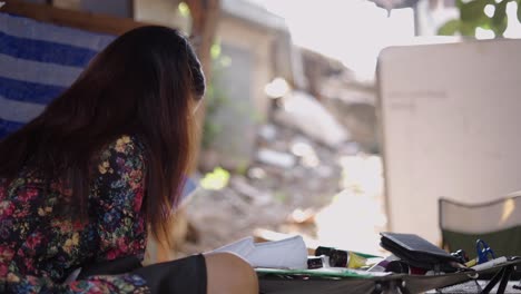 A woman with long hair concentrating on a task outdoors
