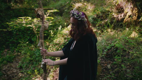 young druid girl contemplates her wooden staff medium shot