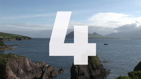 number 5 animation over scenic coastal landscape with rocky cliffs and ocean