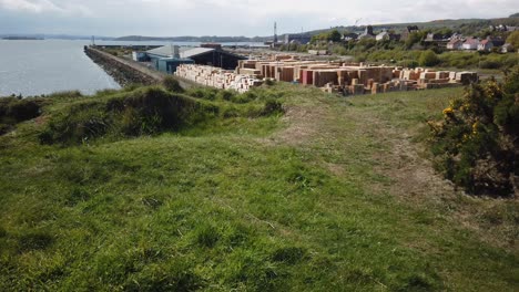 Looking-over-the-firth-of-forth-to-Edinburgh-from-a-grassy-hilltop-with-a-sawmill-in-the-background