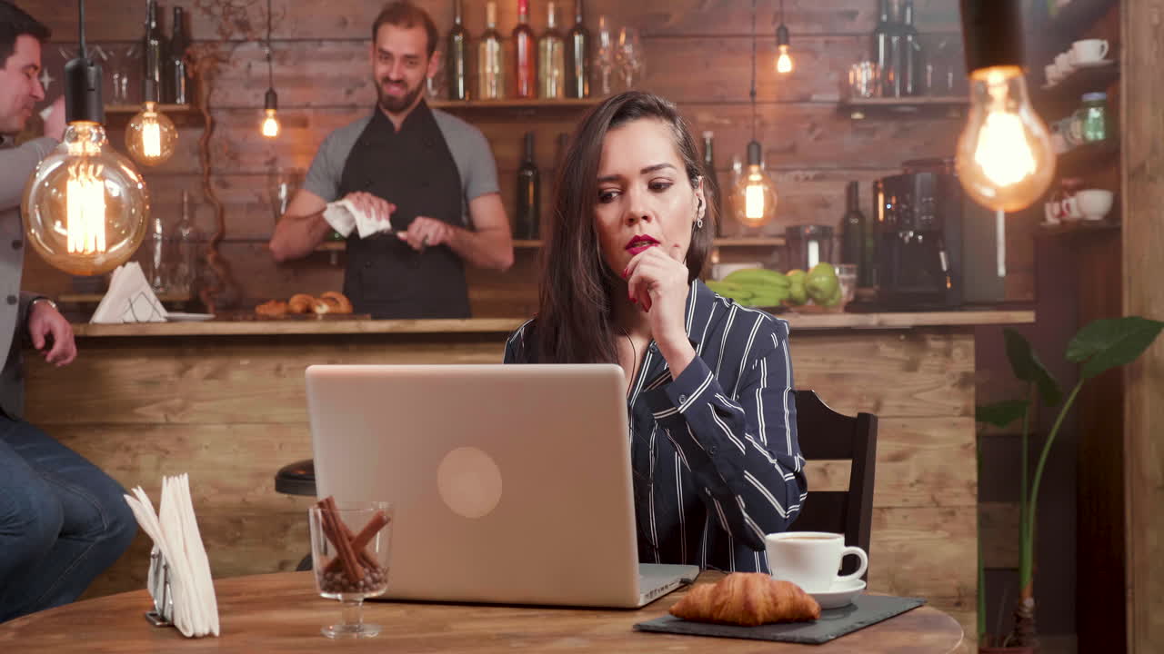Donna che lavora al computer portatile in un caffè