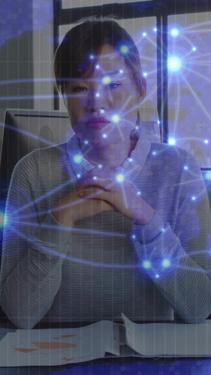 Video verticale: Donna alla scrivania che sfoglia un fascicolo con le mani, avviando una sovrapposizione di nodi blu per la tecnologia