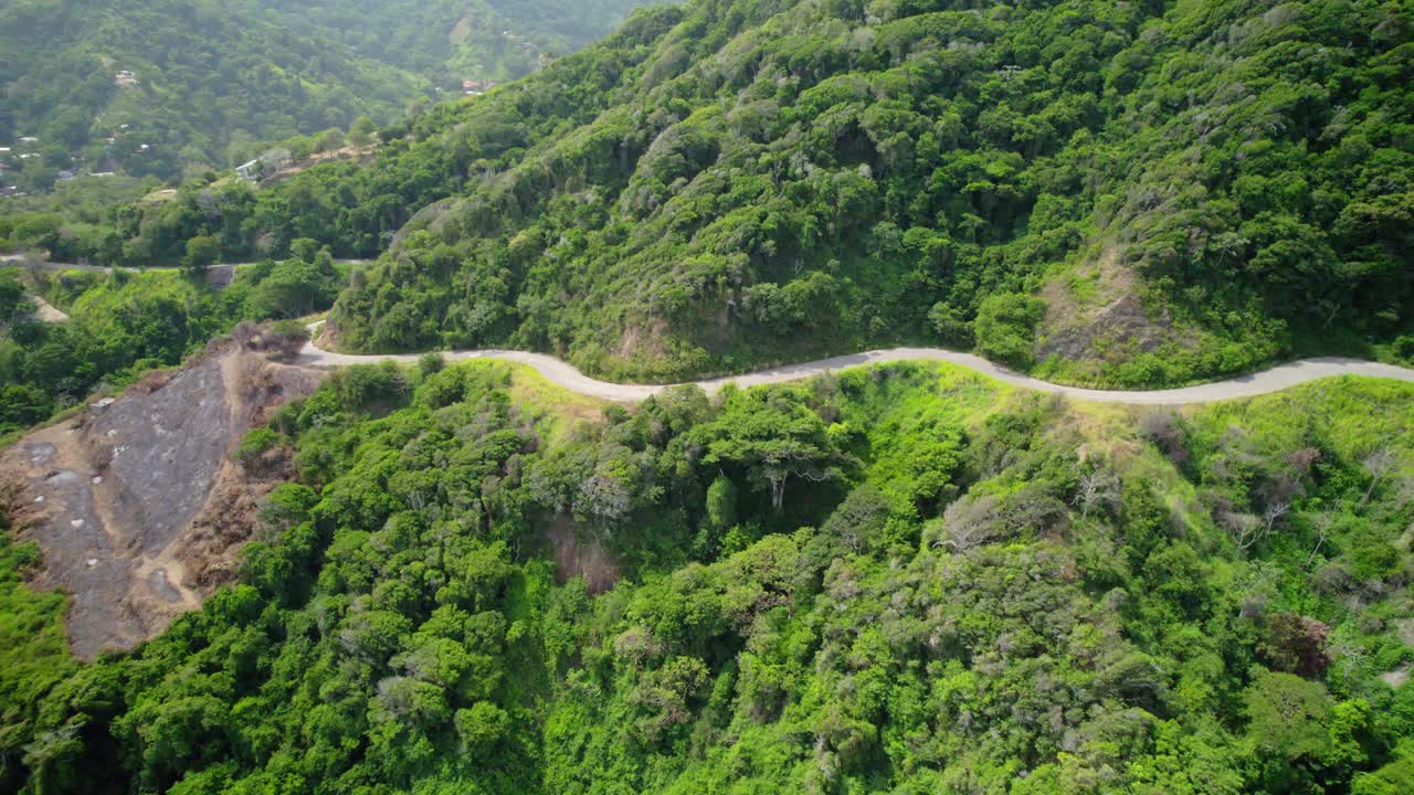 A winding asphalt road through lush green mountains in la guaira, venezuela, aerial view