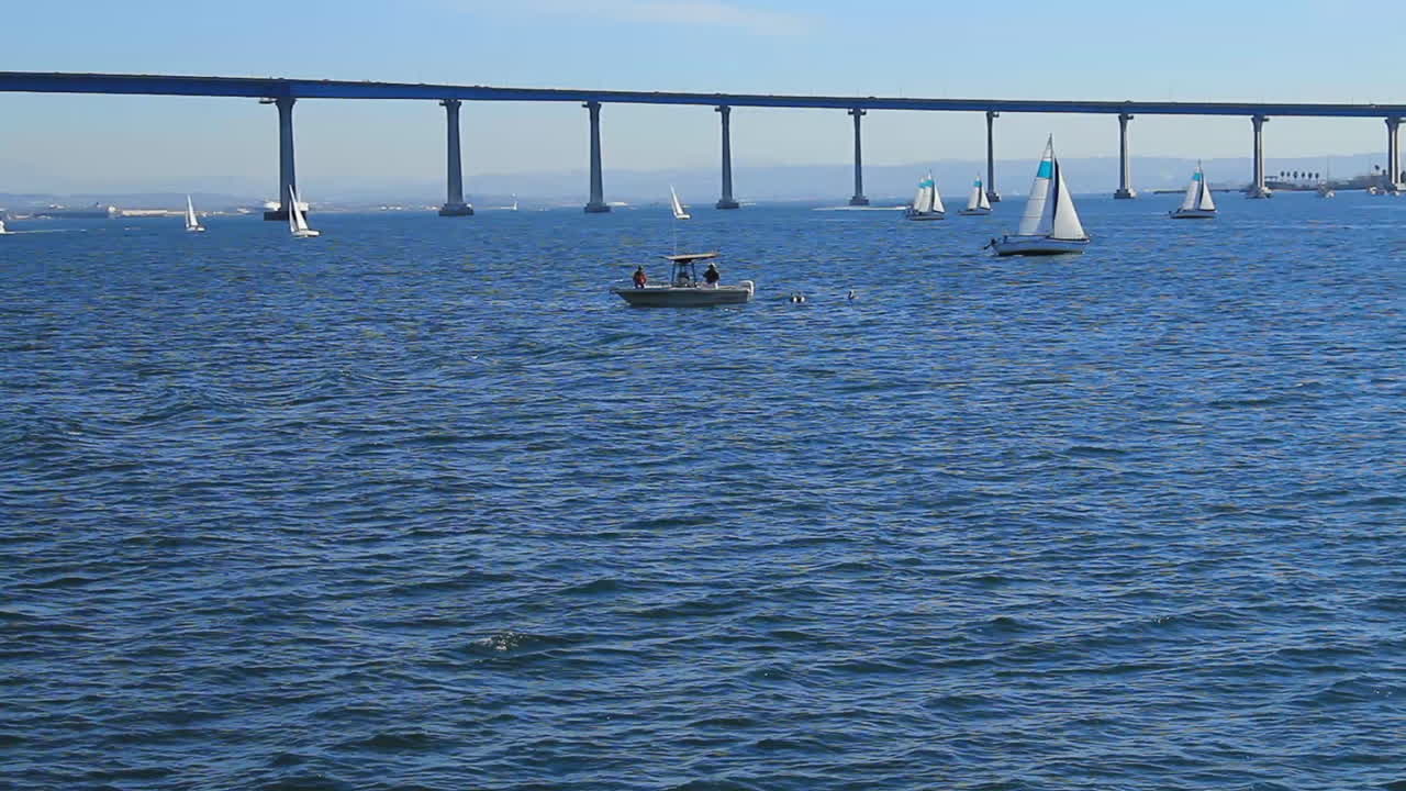 Handheld shot of Coronado bridge in the distance while boating on San Diego Bay