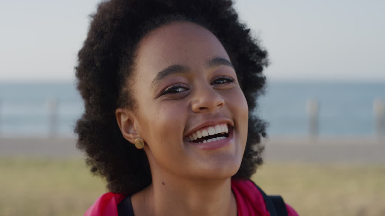 portrait d'une jeune femme afro-américaine mignonne qui rit heureuse profitant d'un style de vie détendu et réussi portant une mode sportive une étudiante noire vivante avec un afro funky