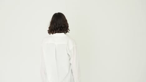 young woman posing in a white shirt against a white background