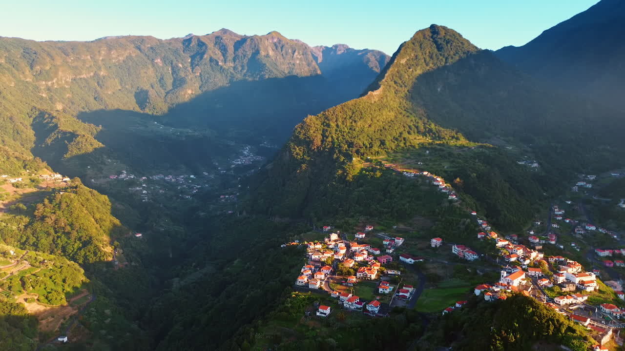 Village located in the mountainous area at the Madeira islands, Portugal. Tops of the mountains are lit with sun.