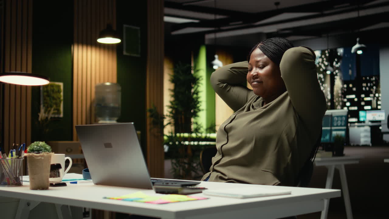 Triumphant associate enjoys a quiet moment of downtime in a corporate office