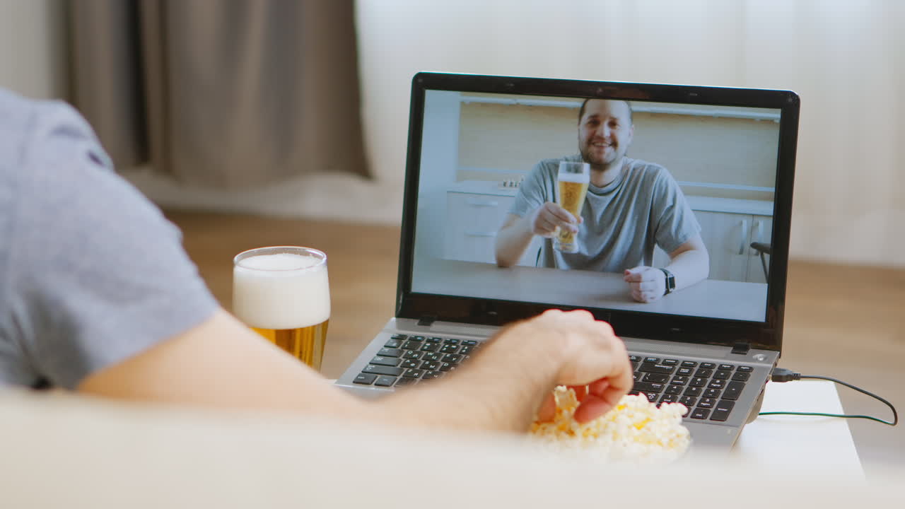 Uomo in videochiamata che beve birra