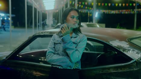 woman smoking near a vintage car at night