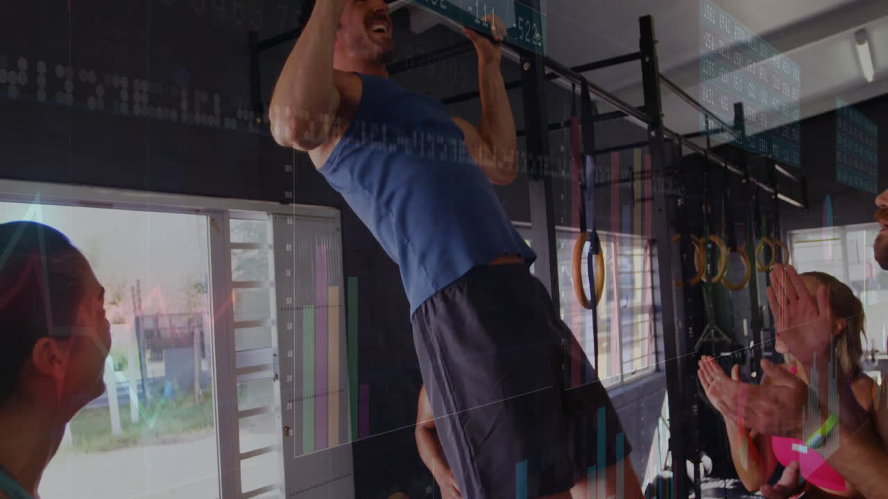 Group of gym mates cheering man pulling up on pull-up bar in fitness, showing data overlays