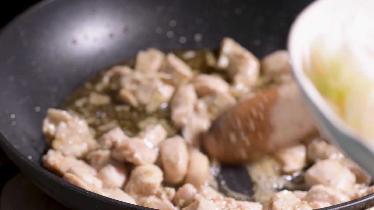 볶은 닭고기를 요리하고 팬에 양파를 넣고, 던지고, 집에서 만든 요리를 만들고, 소프트 포커스 배경으로 닫습니다.